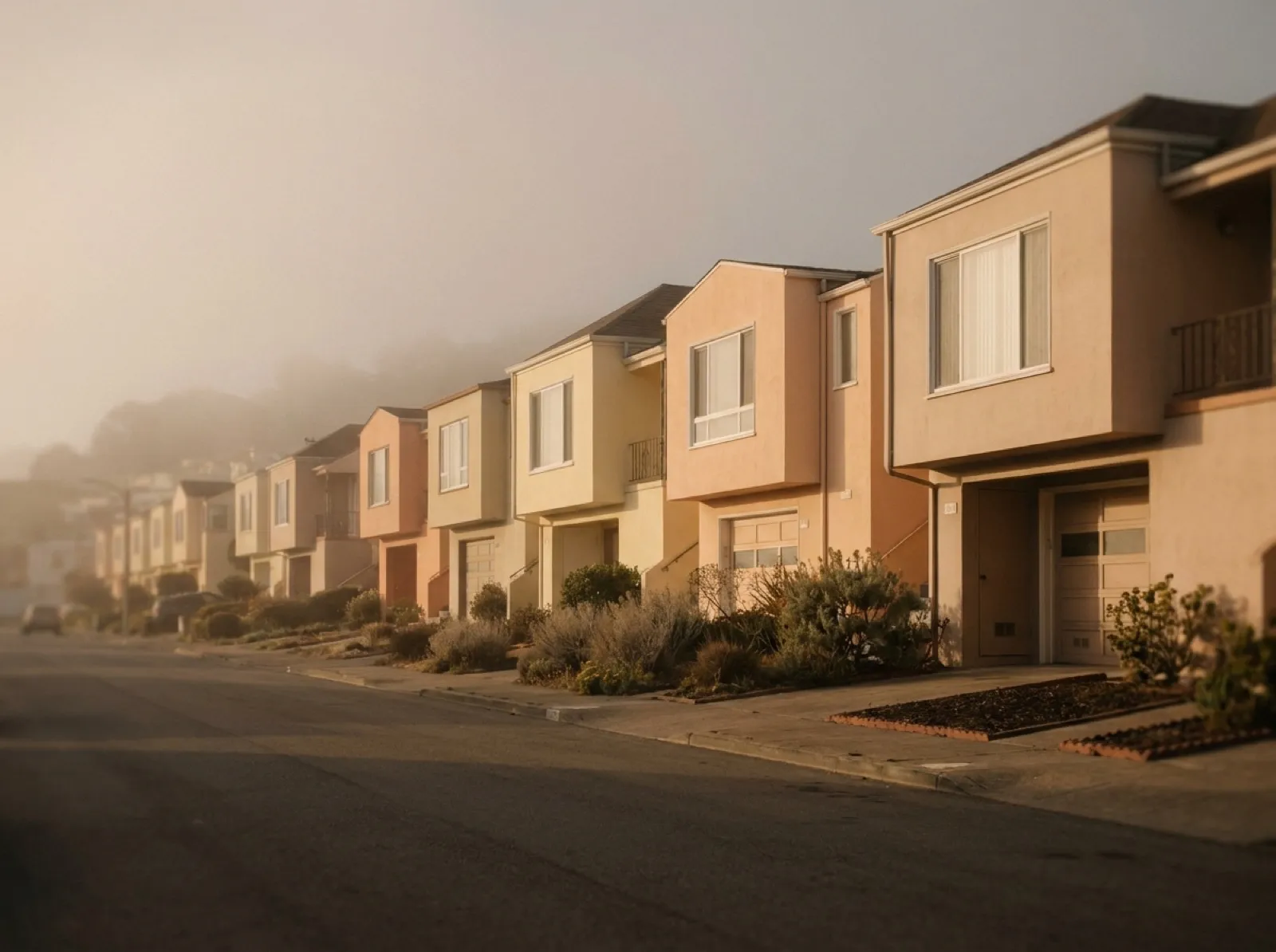 A Daly City residential street — Westlake stucco-over-frame rowhouses